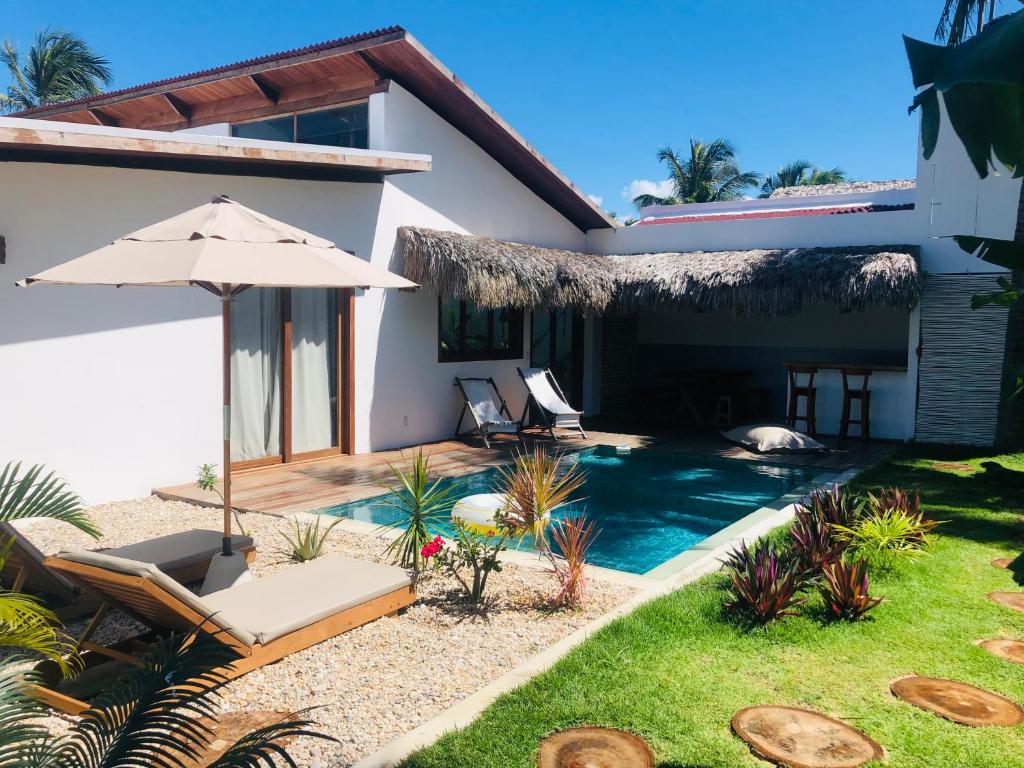 Casa con piscina y sombrilla en Casa Janela da Lua, en Icaraí