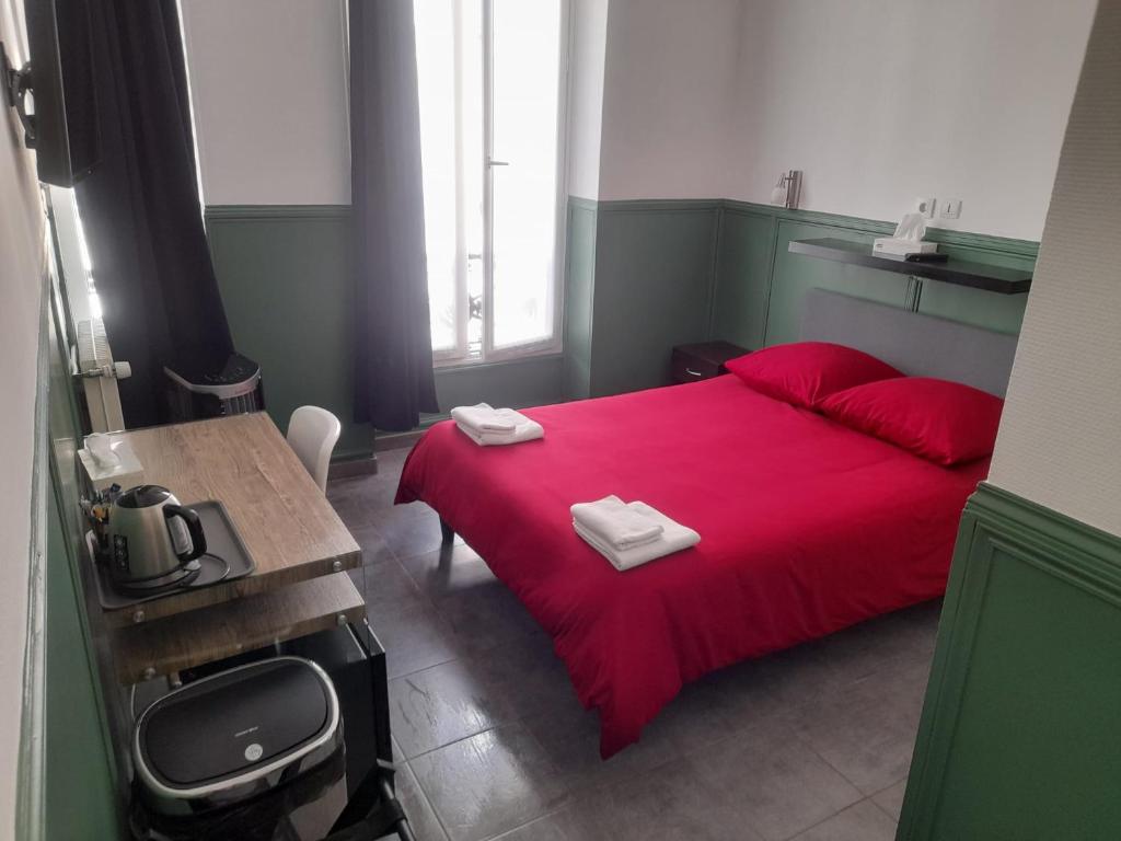 a bedroom with a red bed with two towels on it at Hotel Geoffroy Marie Opéra in Paris