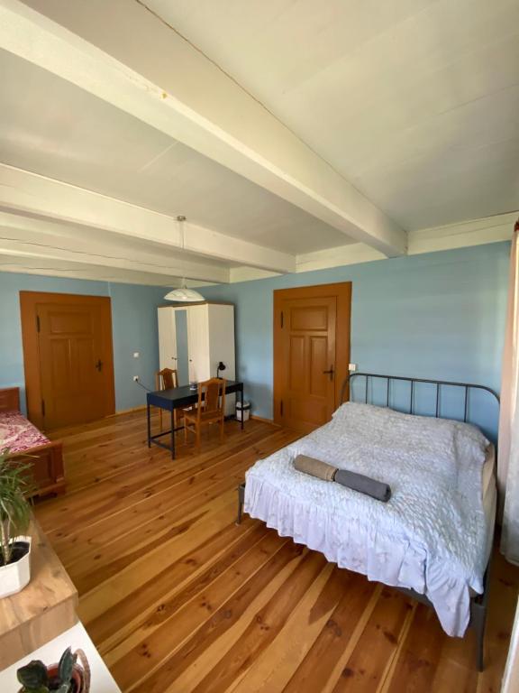 - une chambre avec un lit et du parquet dans l'établissement Zabytkowy Drewniany dom z 1887 roku, à Nowy Dwór Gdański