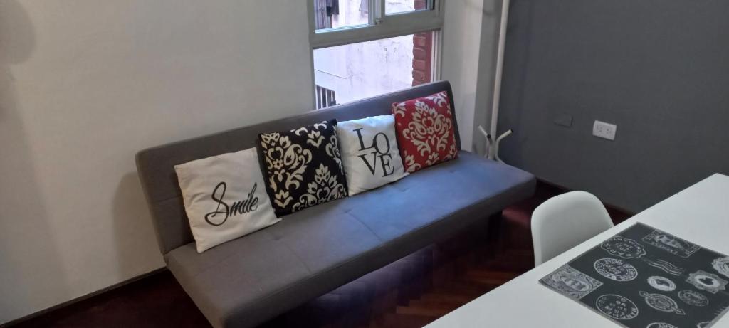 a bench with pillows on it in a room at Departamento céntrico muñecas in San Miguel de Tucumán