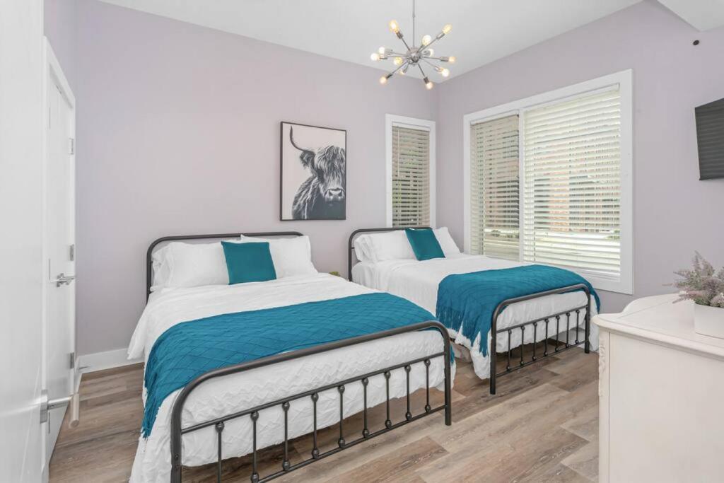 a white bedroom with two beds and a chandelier at Nashville 3 Bed, 1 Bedroom with Washer, Dryer and Parking in Nashville