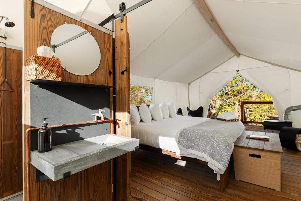 a bedroom in a tent with a bed and a sink at Under Canvas Bryce Canyon in Widtsoe