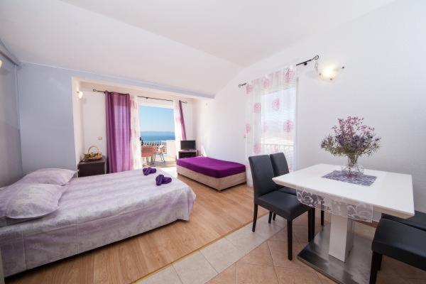 um quarto com uma cama e uma mesa e um quarto com acean em Apartman Goga em Tučepi