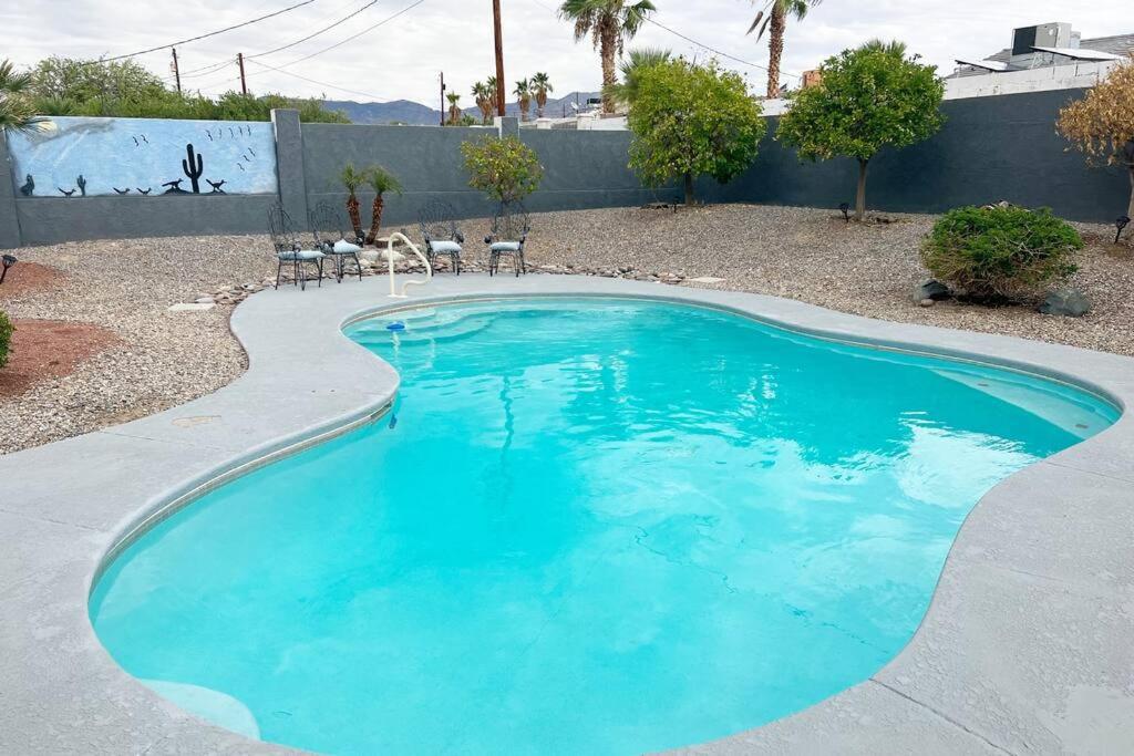 a swimming pool with blue water in a yard at Spacious Getaway! Pool, Spa, Sleeps 9 in Lake Havasu City