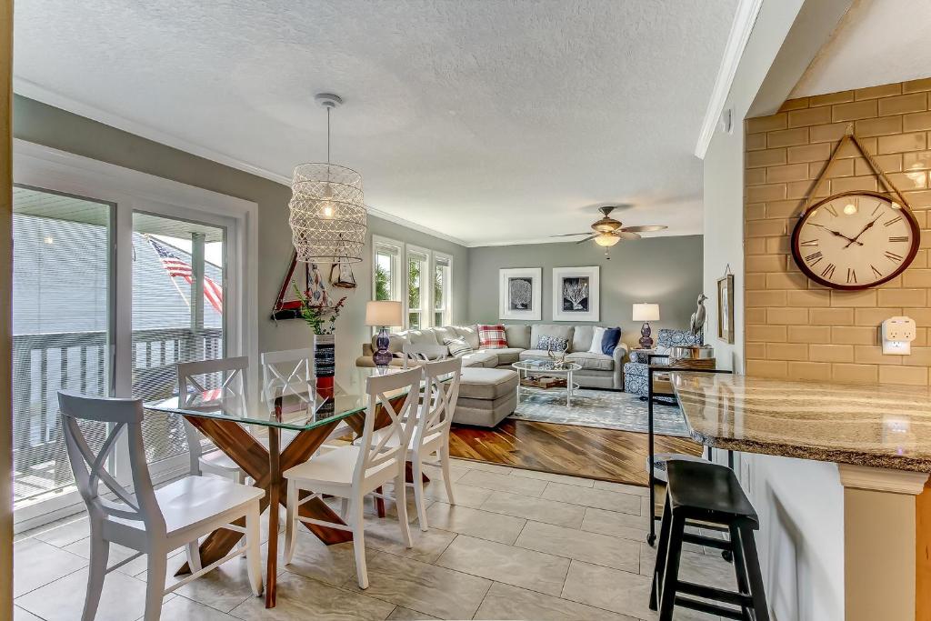 a dining room and living room with a clock on the wall at Walk to Beach-Fernandina Shores 6513-Pool & Tennis-On North End Near Main Beach in Fernandina Beach
