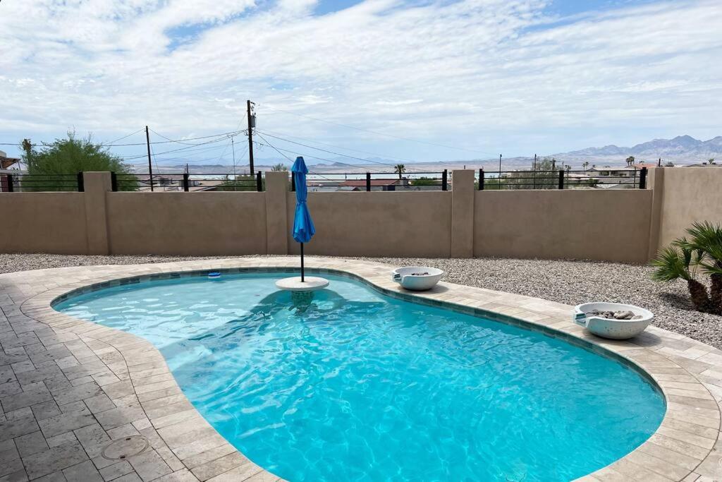 una piscina con sombrilla en un patio en Havasu Retreat! Pool, Spa, Gym & View en Lake Havasu City