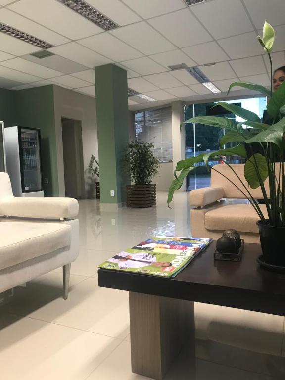 una sala de estar con una mesa con una planta en Pratico Hotel, en Santarém