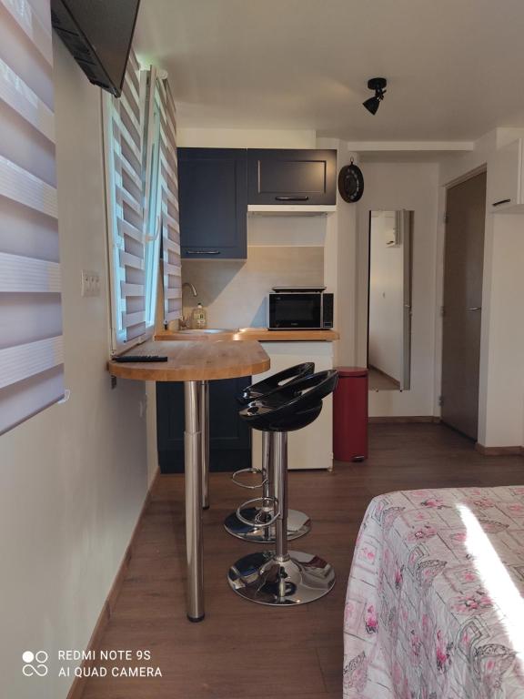 cocina con mesa y 2 taburetes en una habitación en Apartment Albert parking privé gratuit, en Limoux