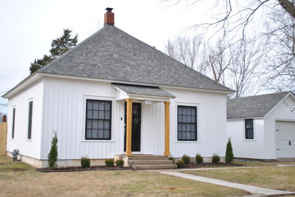una casa blanca con techo gris en Black and white cottage; Simple yet stunning. en Joplin