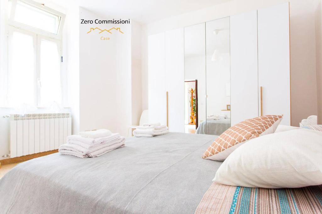 a white bedroom with a large bed with towels on it at Casa Vacanze Licinia - Appartamento centro storico in Citta' Sant'Angelo