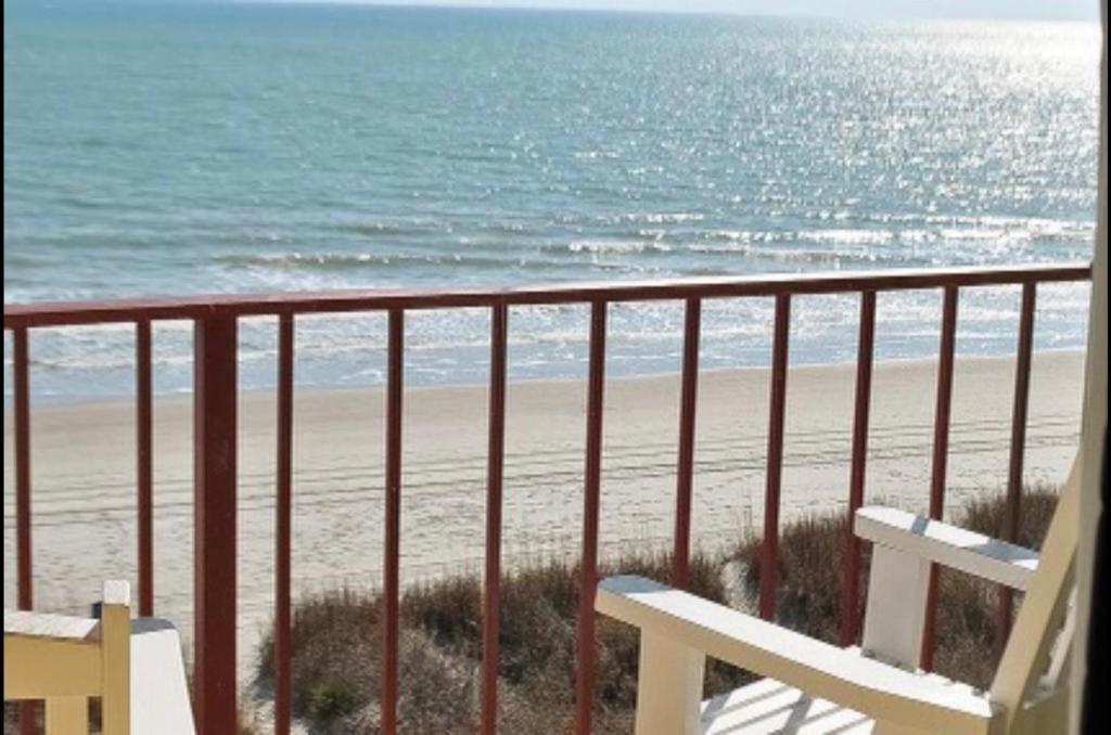 un balcón con vistas a la playa y un banco en Gazebo Inn Oceanfront en Myrtle Beach