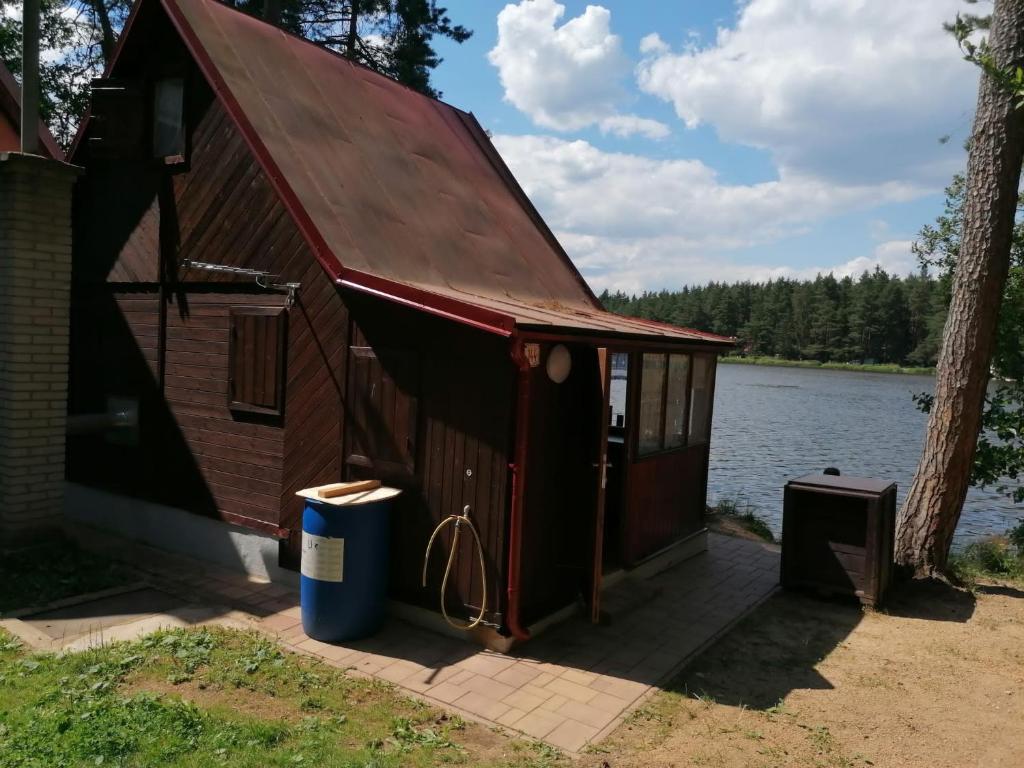 uma pequena cabana ao lado de um lago em Chata Florián em Stráž