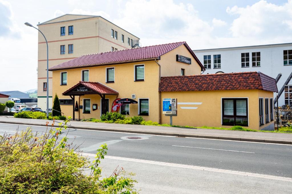 a yellow building on the side of a street at Pension & Gaststätte Zur Salzgrube in Sondershausen