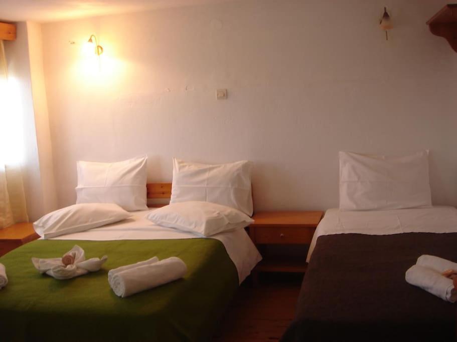 two beds in a room with towels on them at Pension Niki in Skála Sykaminéas