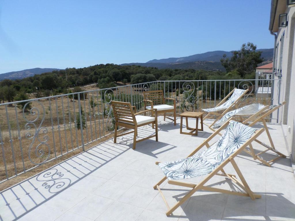 um pátio com cadeiras e um baloiço numa varanda em Villa vue mer et nature route de Cigala em Sollacaro