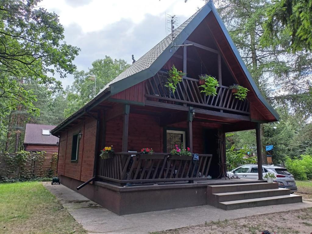 Casa pequeña con porche y balcón en Leśniczówka, en Olszewnica Stara