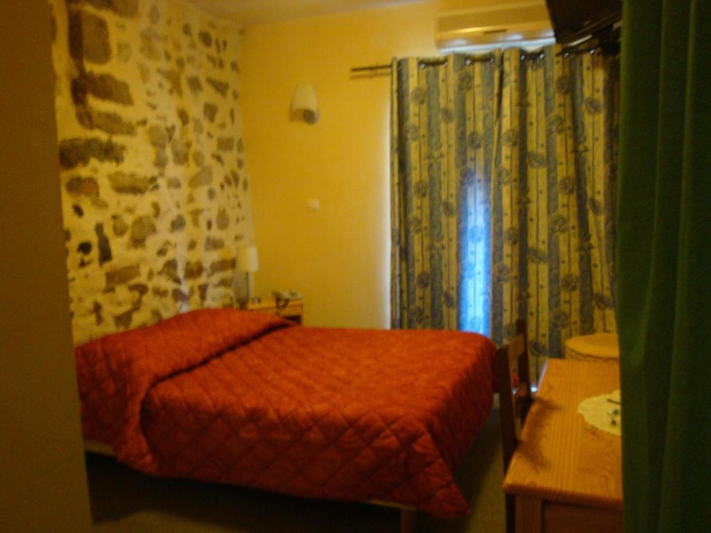 a small bedroom with a red bed and a window at Le Bilboquet in Le Puy-en-Velay