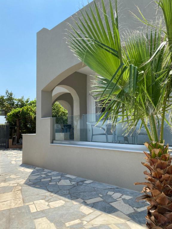 a house with a palm tree in front of it at Beautiful House in Front of the Sea in Gázion