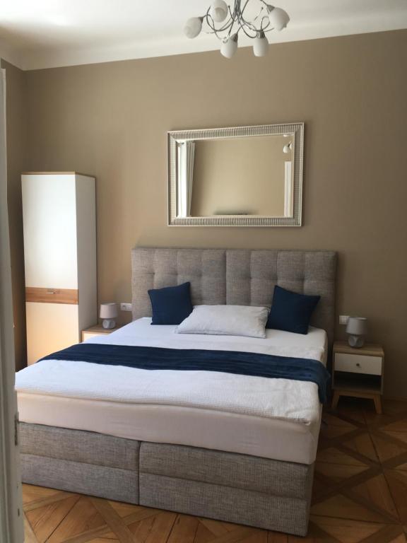 a bedroom with a large bed with blue pillows at Apartment Vertigo in Karlovy Vary