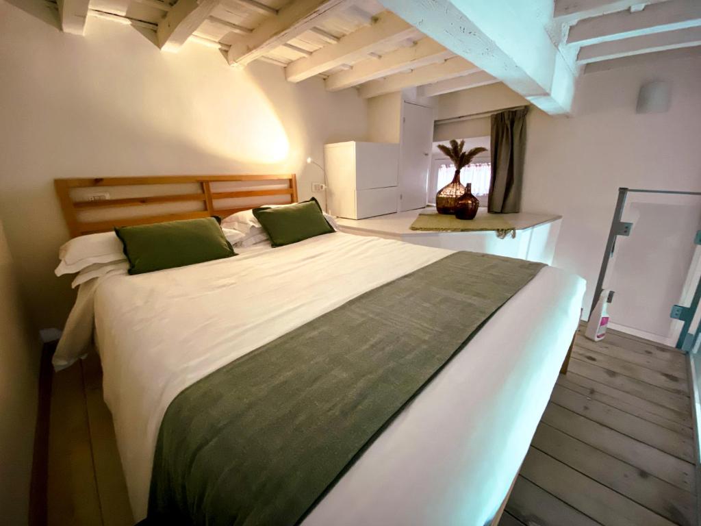 ein Schlafzimmer mit einem großen Bett mit grünen Kissen in der Unterkunft Acacia Firenze - Giglio in Florenz