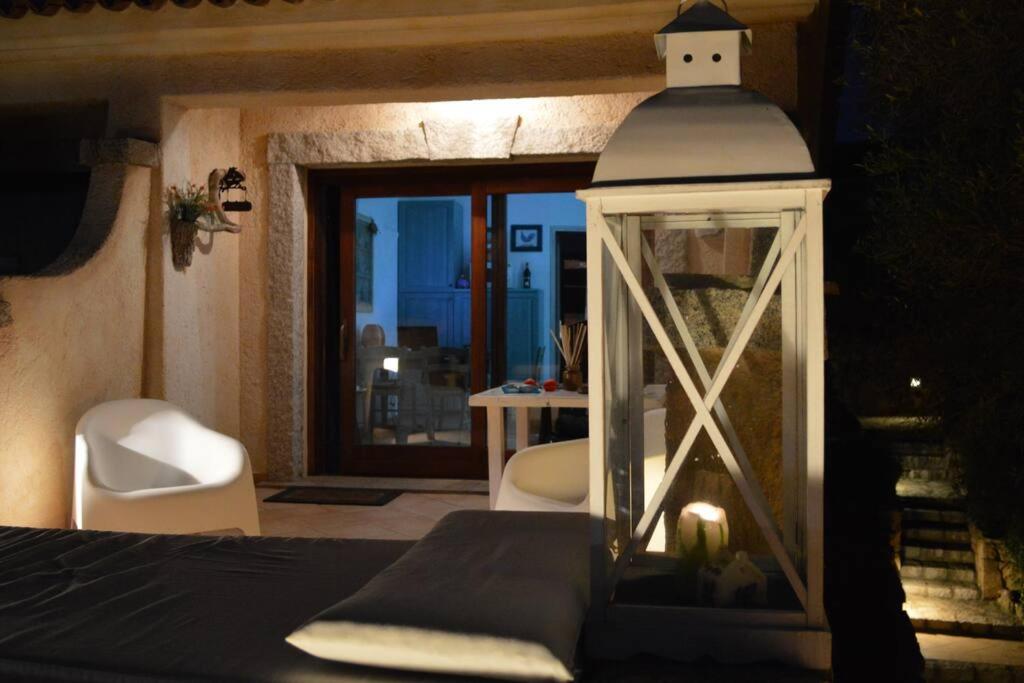 a bedroom with a bed with a lantern and a table at PORTO POLLO WIND & LOVE in Barrabisa