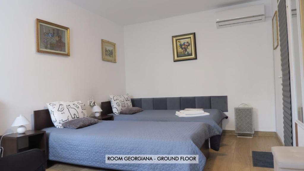 two beds in a room with white walls at Aeroport - Relax Casa Victoria in Otopeni