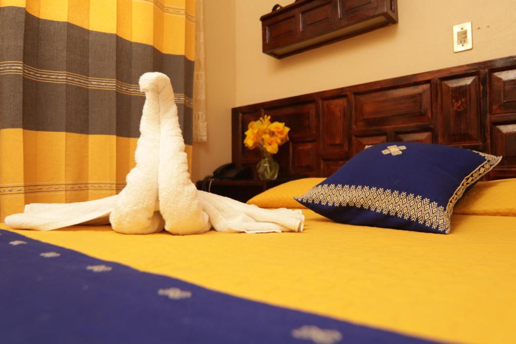 a stuffed giraffe sitting on top of a bed at Hotel Palacio de Moctezuma in San Cristóbal de Las Casas