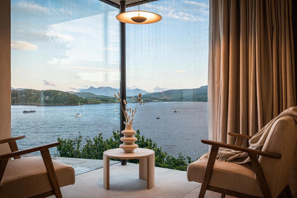 um quarto com uma grande janela com vista para um lago em Vriskaig Luxury Guest Suite with Iconic Views em Portree