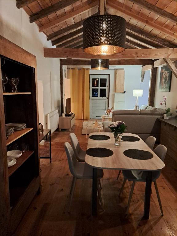 salon ze stołem i kanapą w obiekcie Maisonnette vue sur forêt w mieście Campagne