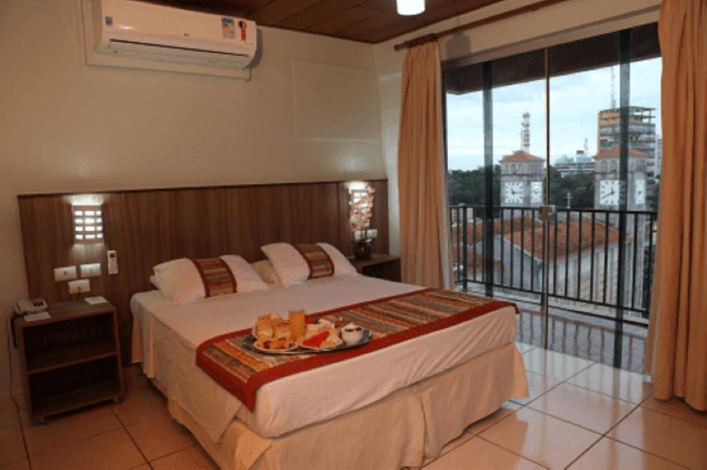 クイアバにあるマット グロッソ パレス ホテルのベッドとバルコニー付きのホテルルーム