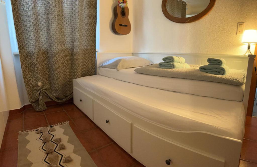 CASA STEFANIA con giardino a LUGANO في Grancia: غرفة نوم عليها سرير وفوط