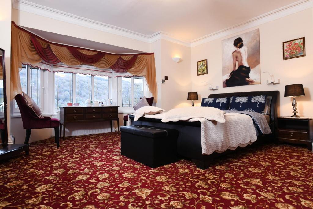 - une chambre avec un lit, un bureau et des fenêtres dans l'établissement Luxury Suite in quiet countryside location, à Swansea