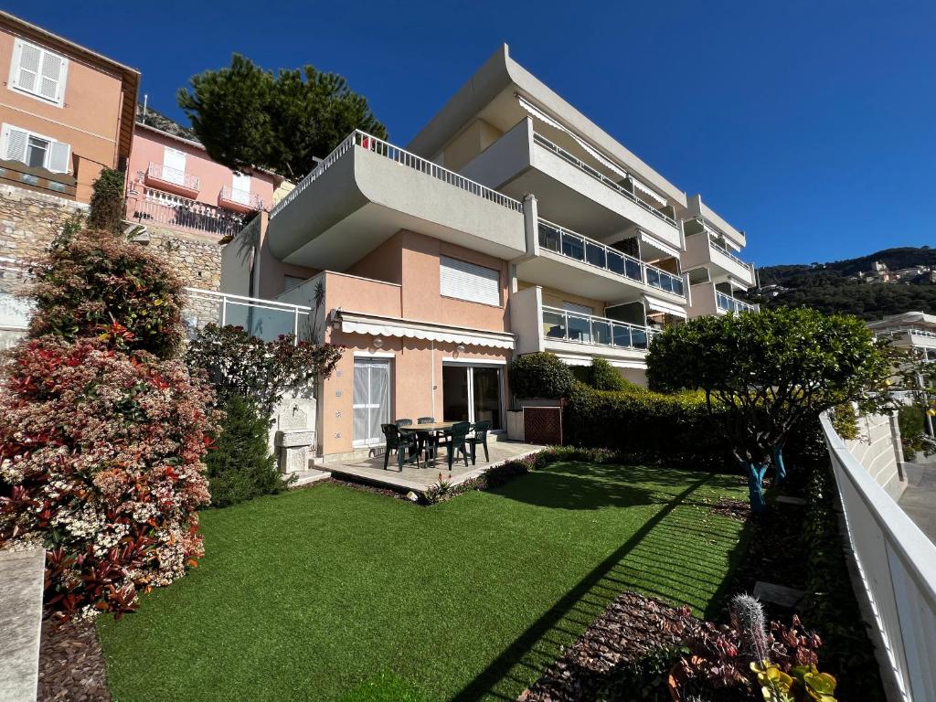 un gran edificio de apartamentos con un patio con césped en Cap d.Azur, en Roquebrune-Cap-Martin