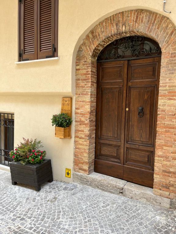 duże drewniane drzwi na boku budynku w obiekcie B&B Vico Suites w mieście Vico nel Lazio
