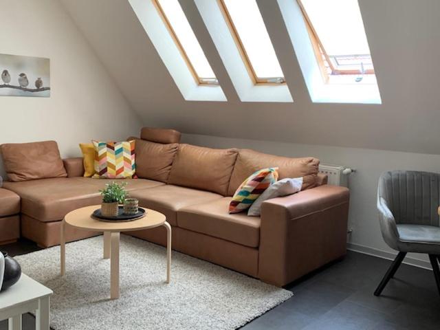 a living room with a brown couch and a table at Ferienwohnung Lüttje Hörn in Emden