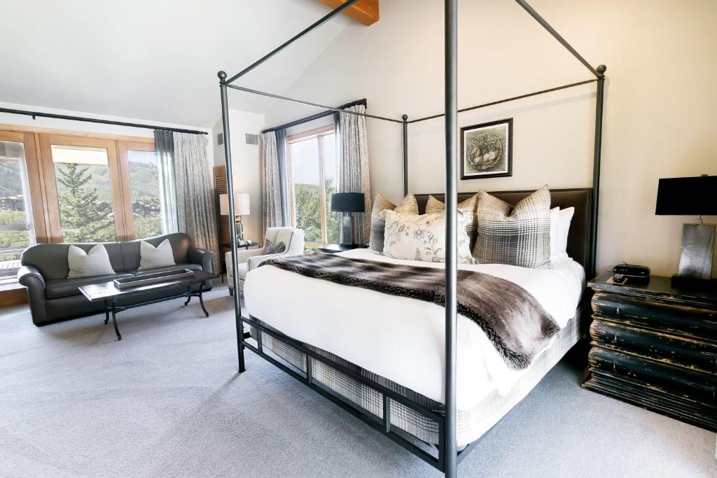 a bedroom with a four poster bed and a couch at Luxury King Room with Mountain View Hotel Room in Park City