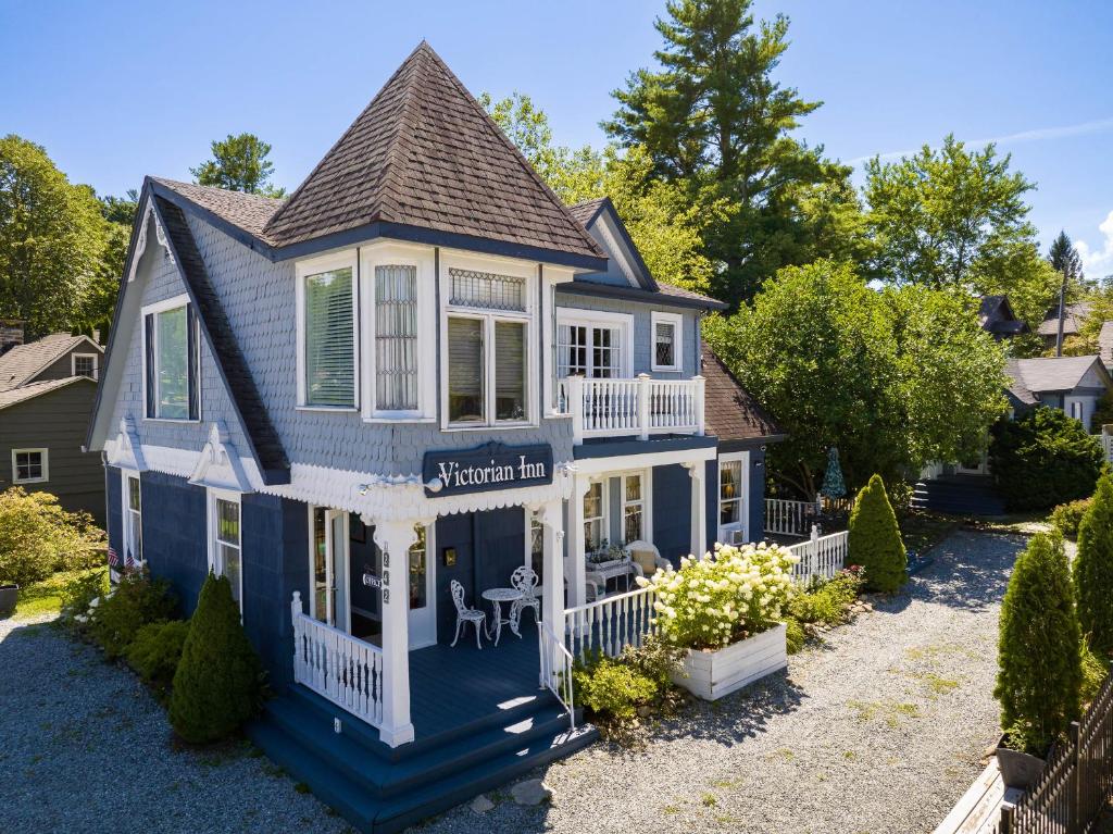 a blue and white house with a porch at The Victorian Inn Blowing Rock in Blowing Rock