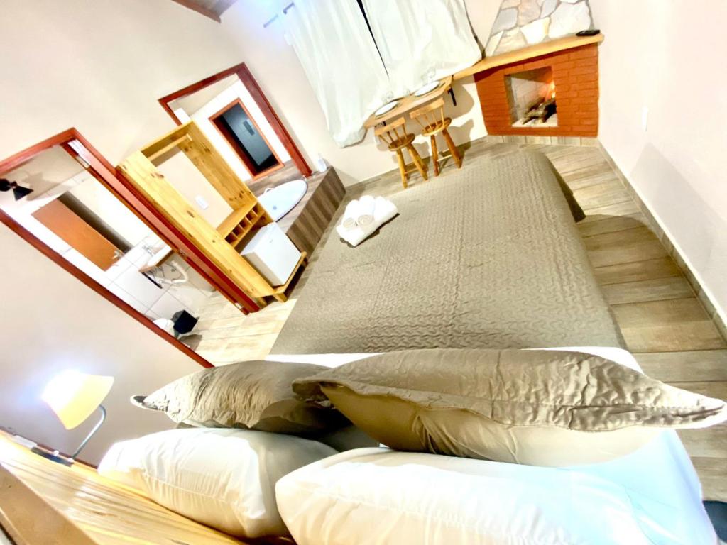 a large bed in a room with two pillows at Chalés Campo Verde in Camanducaia