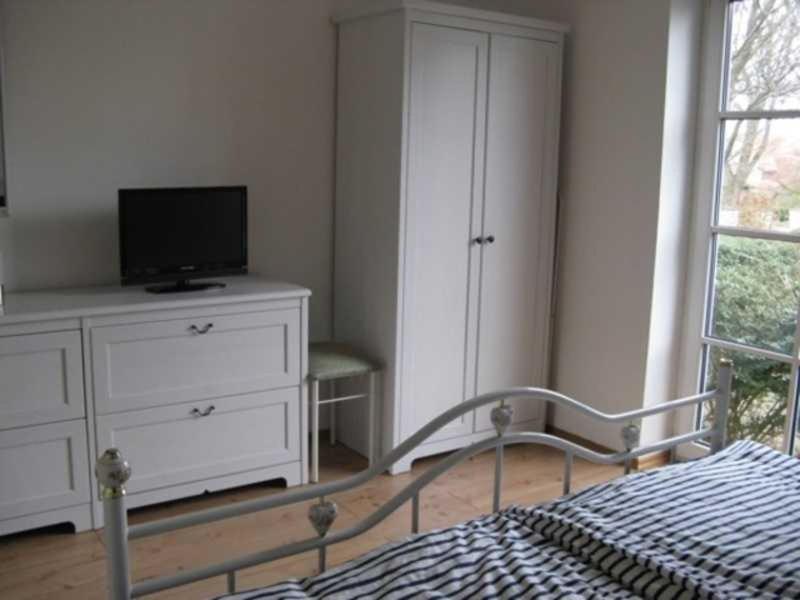シェーンハーゲンにあるFerienwohnung S_stjernのベッドルーム(ベッド1台、ドレッサー内のテレビ付)