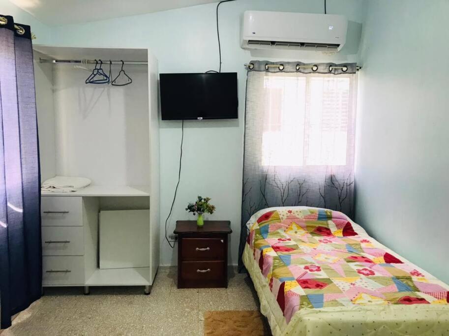 um quarto com uma cama, uma secretária e uma janela em Apto 2Habitaciones con Aire y Vista al Malecón de Samaná em Santa Bárbara de Samaná