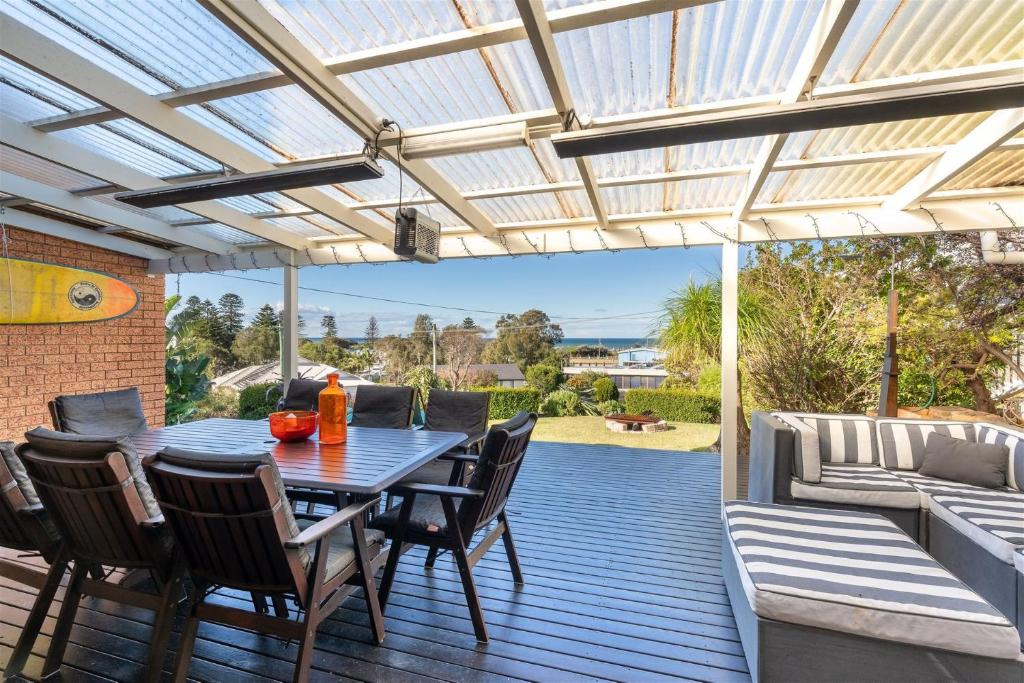a patio with a table and chairs on a deck at Casa Moana in Gerringong