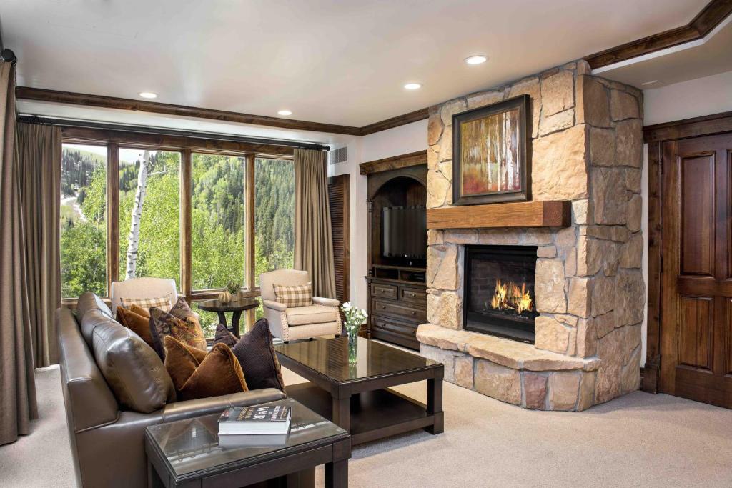 a living room with a large stone fireplace at Junior King Suite Hotel Room in Park City