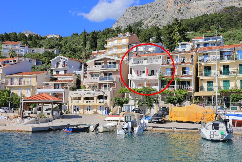 un edificio con un círculo rojo delante de él en Apartments by the sea Podgora, Makarska - 11432, en Podgora