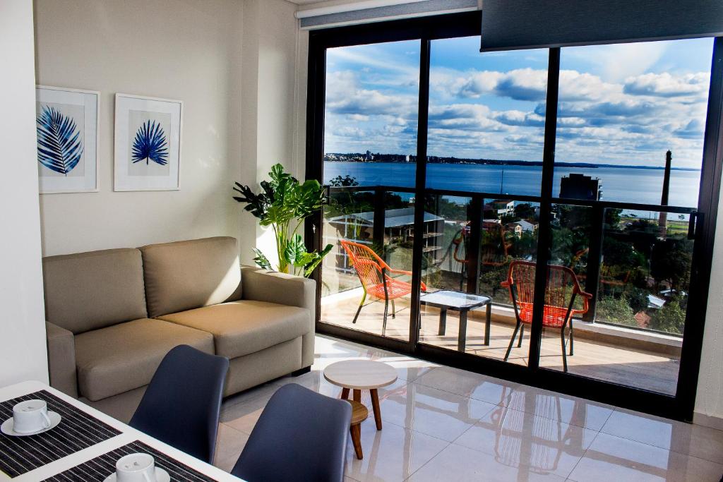 a living room with a couch and a large window at Apartamento en Sognare in Encarnación