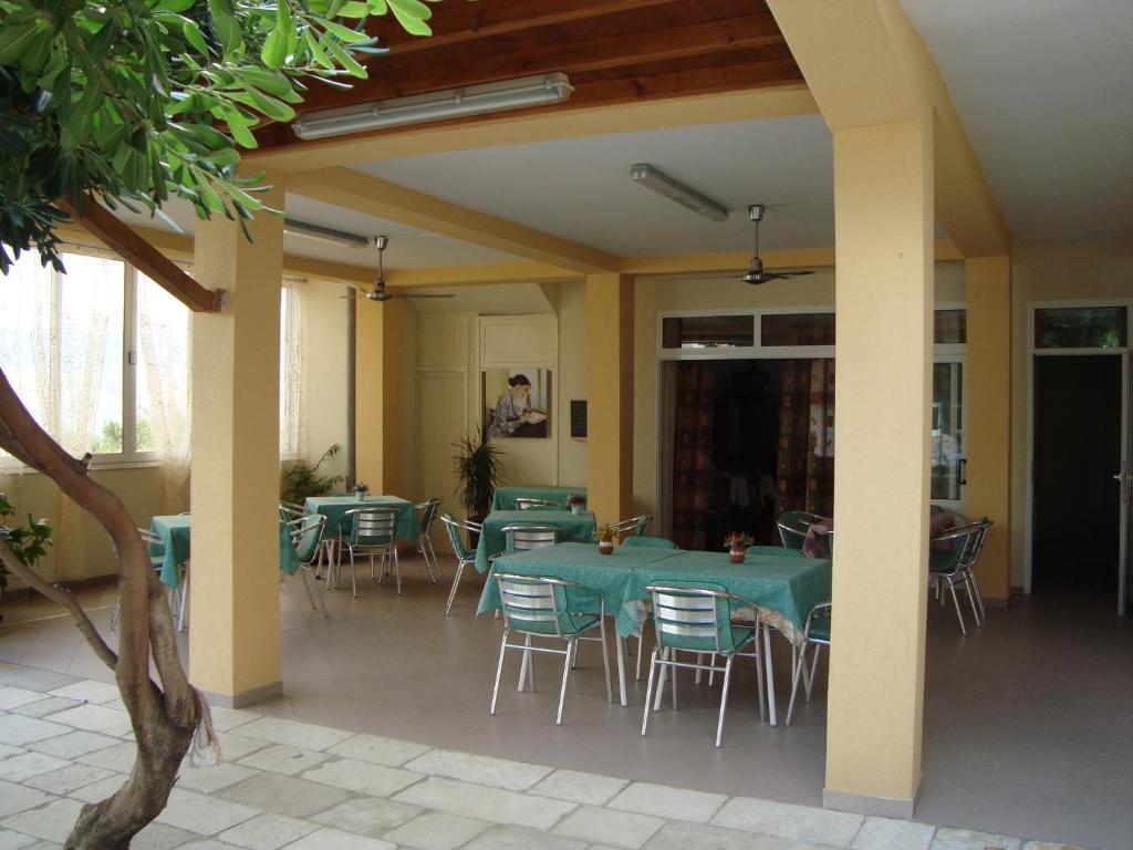 jadalnia z zielonymi stołami i krzesłami w obiekcie Apartments and rooms by the sea Pag - 11487 w mieście Pag