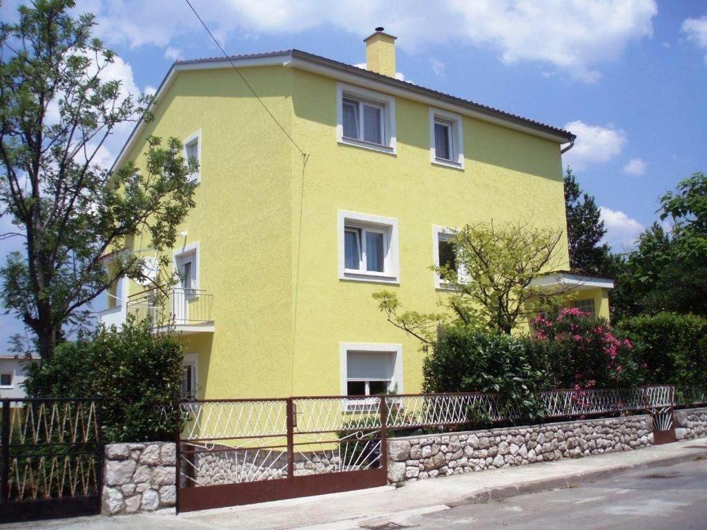 a yellow house with a fence in front of it at Apartments with a parking space Selce, Crikvenica - 11527 in Selce