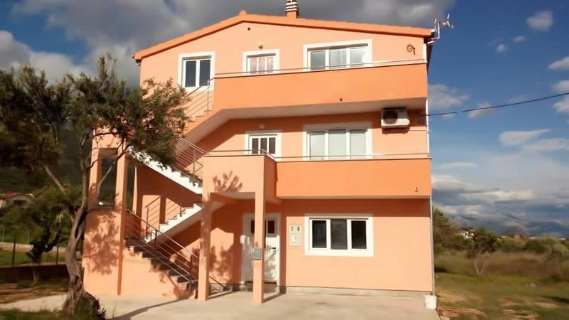 a pink house with a tree in front of it at Apartments with a parking space Kastel Stari, Kastela - 11571 in Kaštela
