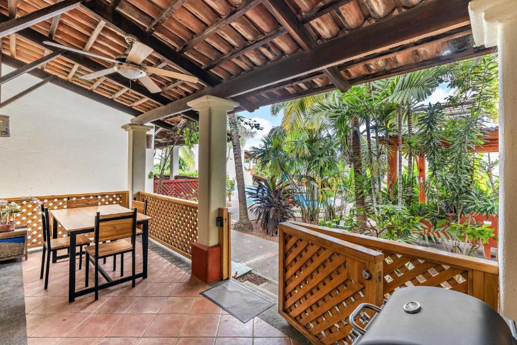um pátio exterior com uma mesa, cadeiras e palmeiras em Colorful, Classy, Modern Split-Level Near Beach with Pool em Coco