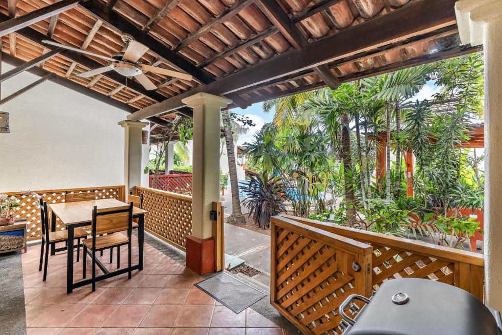 un patio al aire libre con mesa, sillas y palmeras en Colorful & Private 2-Bedroom Condo Just a Short Walk from the Beach, en Coco