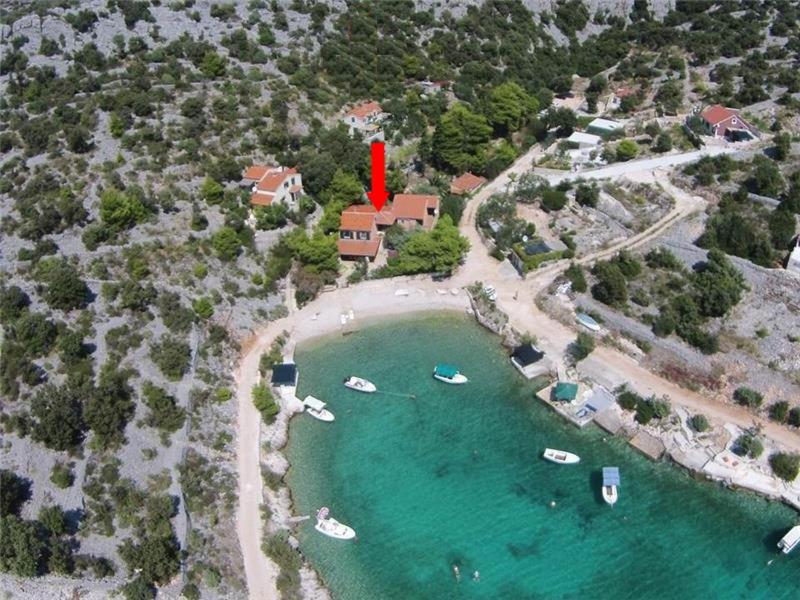 z góry widok na dom z łodziami w jeziorze w obiekcie Apartments by the sea Sevid, Trogir - 11529 w mieście Sevid